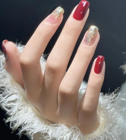 Dark red coffin-shaped nails featuring a glitter accent for a glamorous and bold look.